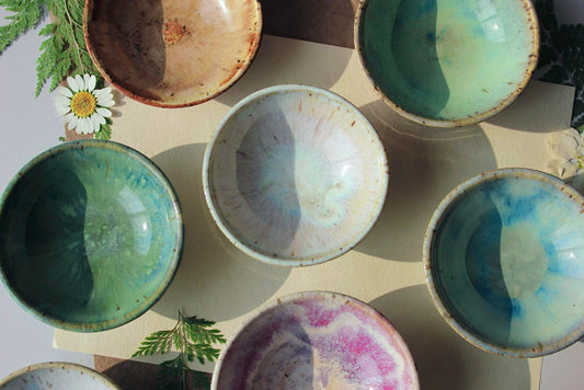 A collection of handmade ceramic ring dishes in various colors, including pearl, cinnamon, sapphire, and seafoam glazes, perfect for jewelry and trinkets.