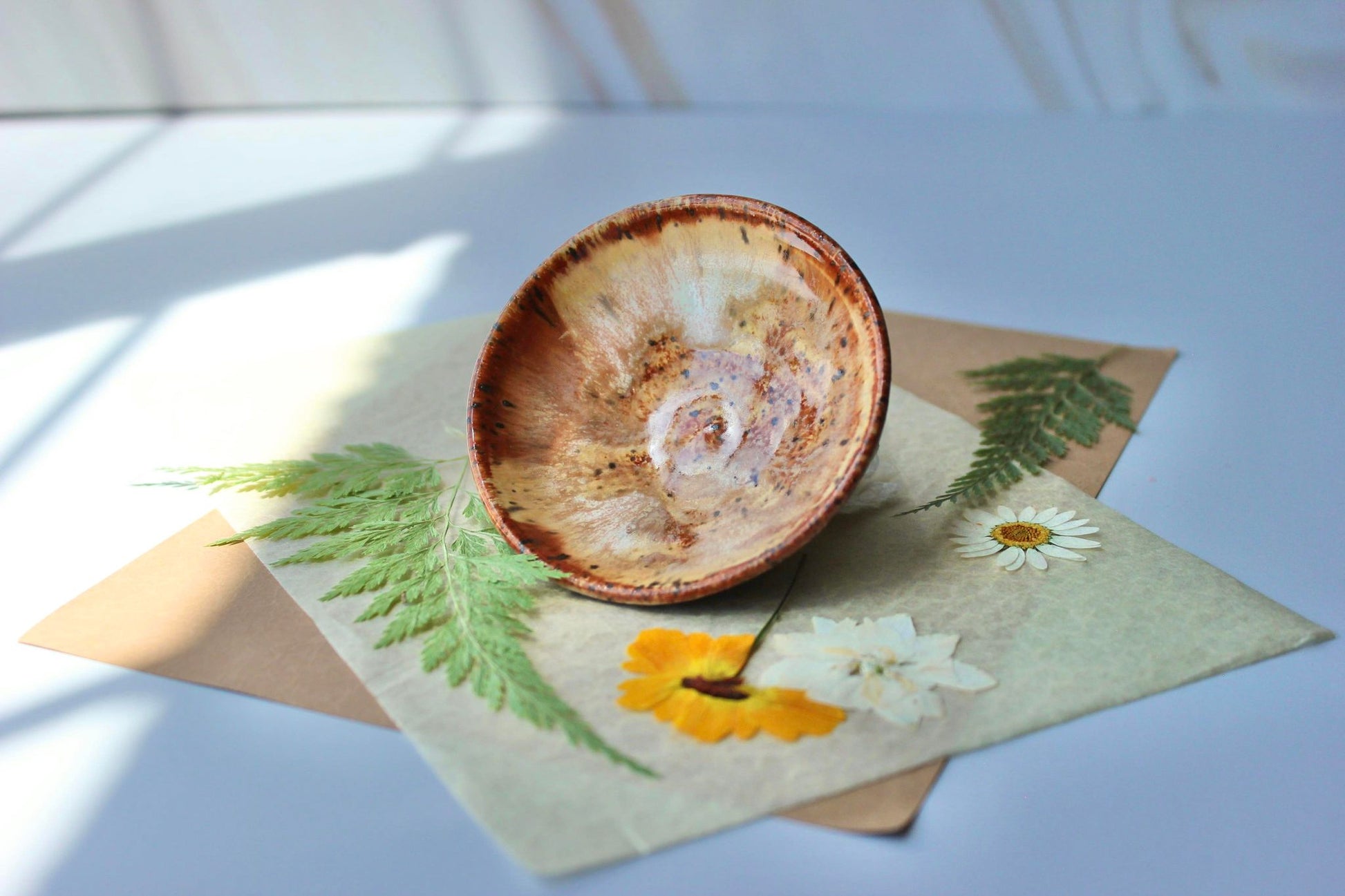 Cinnamon ring dish, a handcrafted jewelry holder featuring rich orange-brown hues and soft cream highlights.